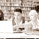 College Essay after affirmative action ended: Four multiethnic schoolmates look at laptop in library discussing information they see on screen