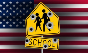 Mass shootings: American flag in background with centered yellow and black school crossing sign with 7 bullet holes.