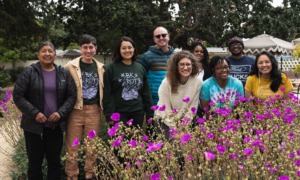 community-based environment, sustainability, climate, education grants: group of people smiling with beautiful flowers in foreground