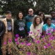 community-based environment, sustainability, climate, education grants: group of people smiling with beautiful flowers in foreground