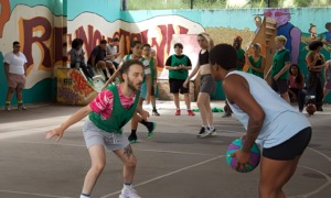 Transgender basketball league: Teams play game on basketball court with crowd on the sidelines