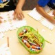 Teacher expenses, what teachers buy for their classrooms with their own money: hands of children working at table with crayons, pencils, glue, scissors and paper