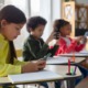 School cell phone bans hit most states: group of young students on their phones in classroom