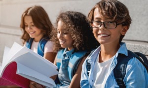 Santa Fe middle school student support grants: three happy middle schoolers sitting and looking at notebook