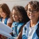 Santa Fe middle school student support grants: three happy middle schoolers sitting and looking at notebook