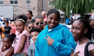 Bronx community grants, health organization support grants: group of happy black youth smiling and throwing "peace sign" at camera