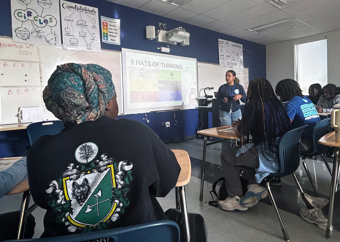 Teachers toss their lesson plans, give students the floor to grapple with Trump win: view from behind seated student looking at teacher and smartboard at front of class