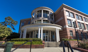 Rural college major elimination: Traditional 3-story red brick building with round tower and round white pillars with cement steps leading up to multiple doors