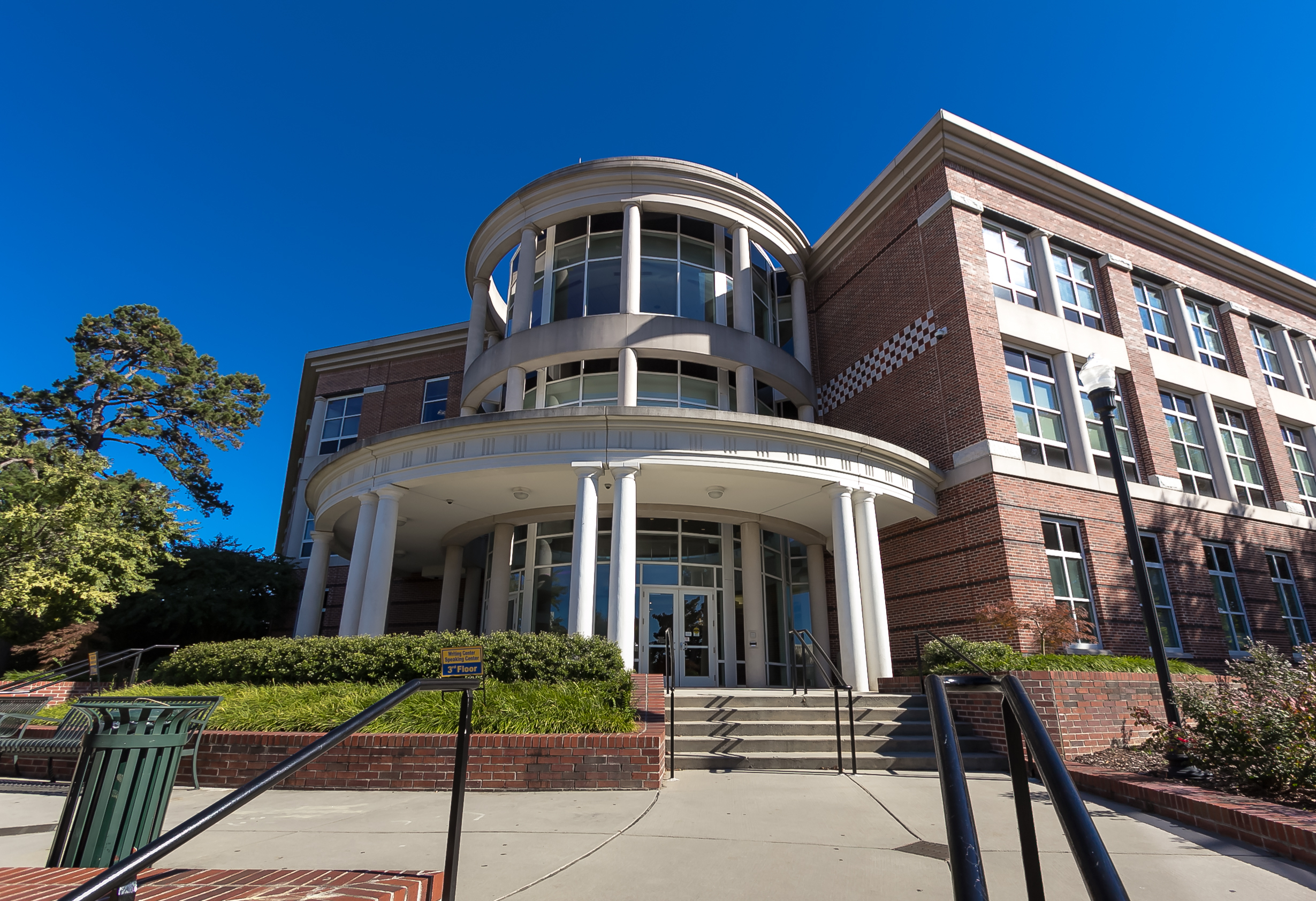 Rural college major elimination: Traditional 3-story red brick building with round tower and round white pillars with cement steps leading up to multiple doors