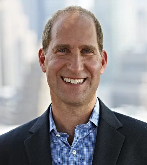 College listening cohort: Headshot man balding light brown hair in dark suit and light blue shirt