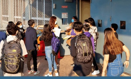 NYC network of school serving immigrants preparing for Trump: group of students, some in masks, entering school building