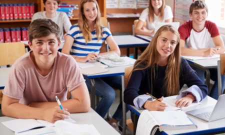 Amite segregation academies: Classroom of all-white teen sitting at desks smiling into camera