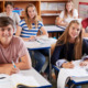 Amite segregation academies: Classroom of all-white teen sitting at desks smiling into camera