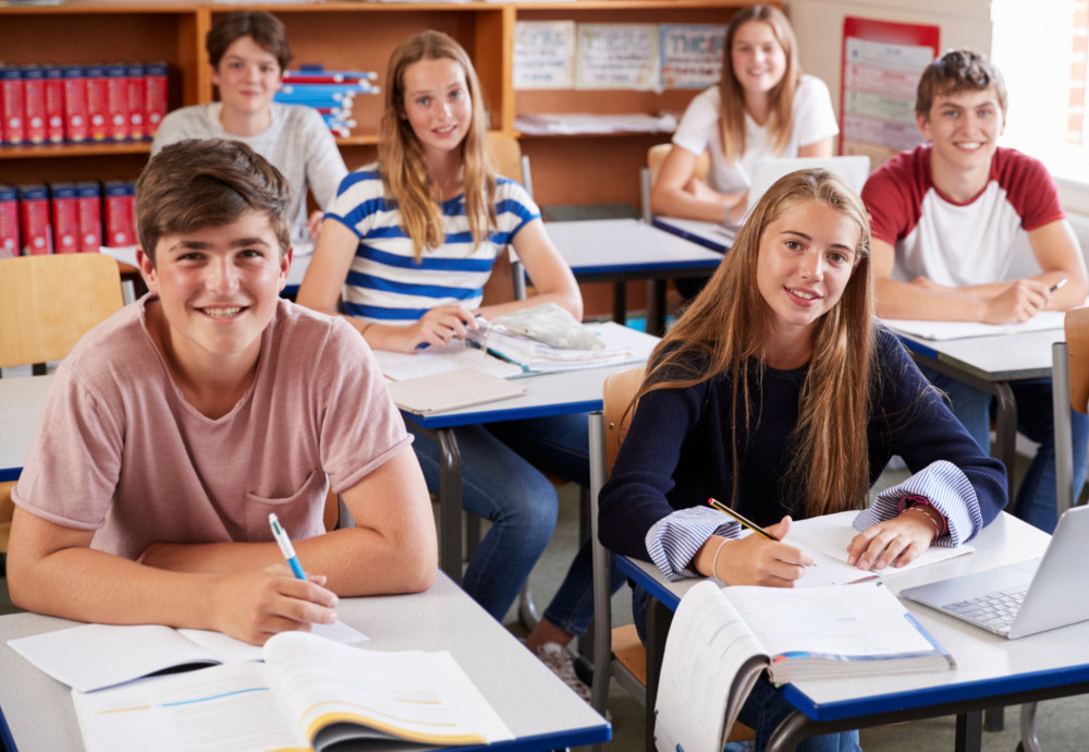 Amite segregation academies: Classroom of all-white teen sitting at desks smiling into camera