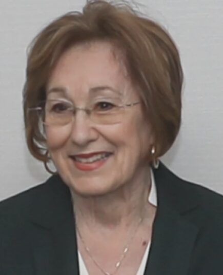 Immigration & scools: Headshot mature woman with short brown hair in navy suit