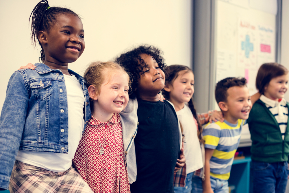 Childcare like Hunger Games: several young children stand in a line with arms around each others shoulders