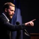 Oklahoma check students' parents document: Man with short brown hair in navy suit stands speaking at podium while gesturing with pointing right hand