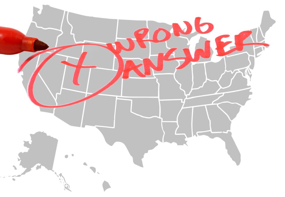 AMericam test scores: outline map of US in gray with text in red printing "Wwrong Answer" and red X n red circle across the whole map