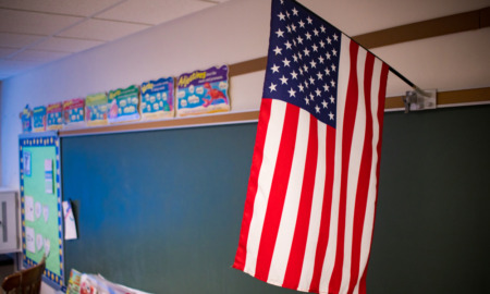 Education in 2025: American flag hanging in front of classroom chalkboard