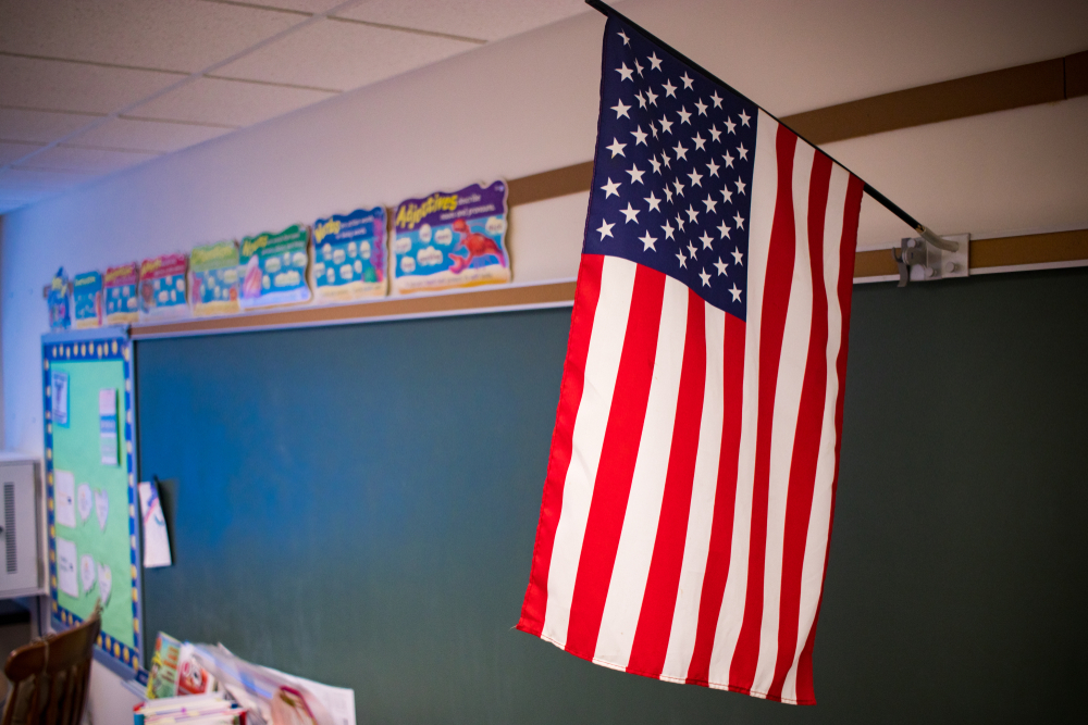 Education in 2025: American flag hanging in front of classroom chalkboard