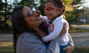 Parents of premature babies struggle to get help their children are entitled to: mother holding a child in arms smiling while child laughs