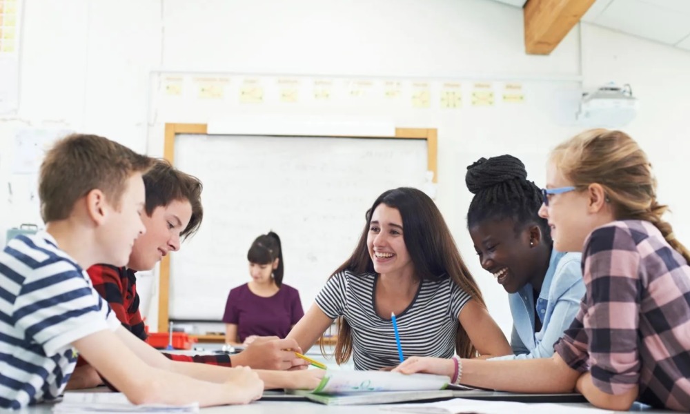 The disengagement gap_Why student engagement isn’t what parents expect: group of students smiling and working at classroom table