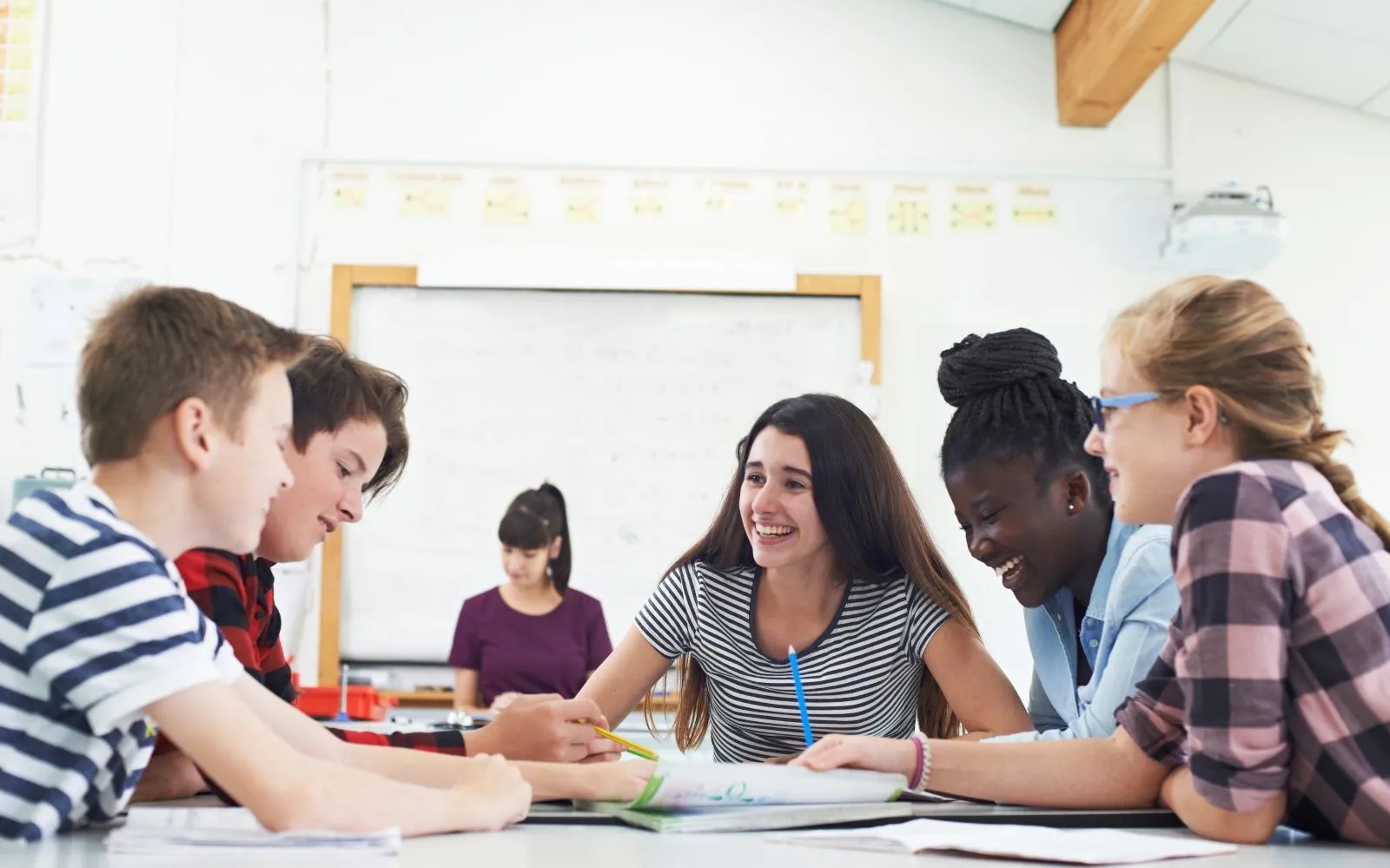 The disengagement gap_Why student engagement isn’t what parents expect: group of students smiling and working at classroom table