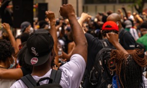 Black-led community organization and movement building support grants: predominately black protestors holding hands up in fists for solidarity during protest