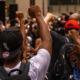 Black-led community organization and movement building support grants: predominately black protestors holding hands up in fists for solidarity during protest