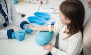 Child health research grants: doctor hold little girls arm while taking blood pressure
