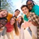 Thriving youth: Multi-ethnic group of 7 teenagers standing together laughing and smiling into camera