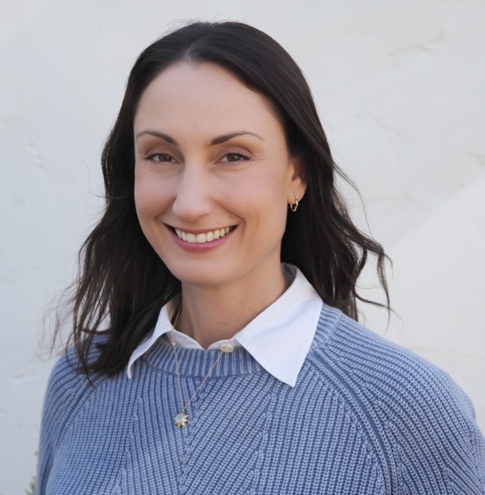 Climate change and adolescents: WOman with long brown hairin gray sweater with white collar