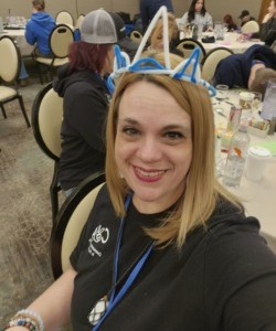 What rural students need: Headshot blonde woman with long bobbed hair in dark top with blue and white pipe cleaner crown on top of her head