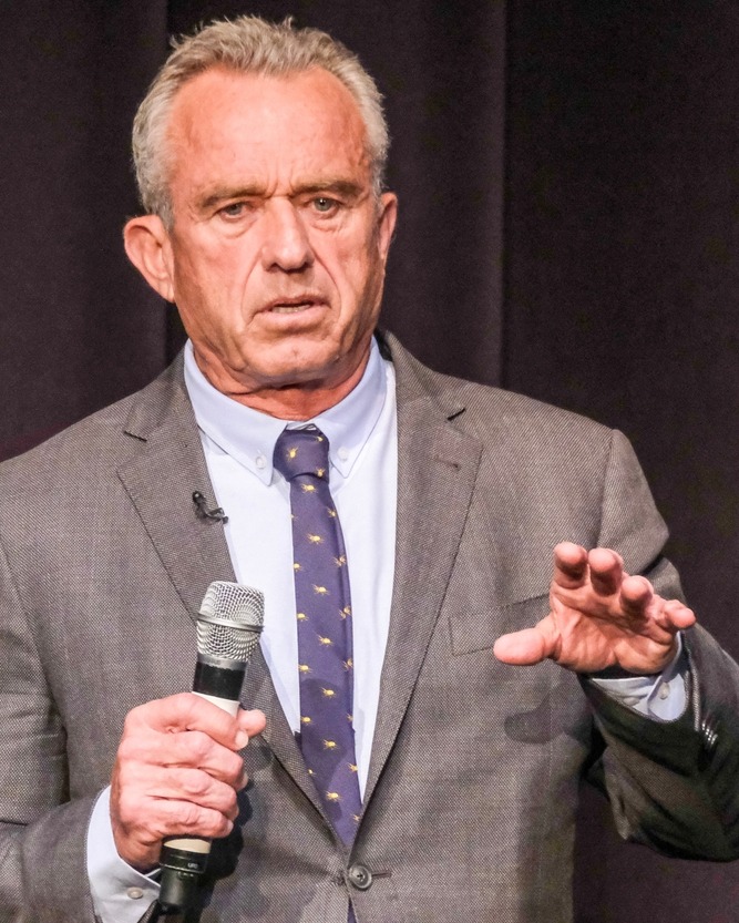 Whooping Cough & Measles outbreak: Robert Kenneday Jr. Standing and gesturing with left hand while holding microphone in right hand