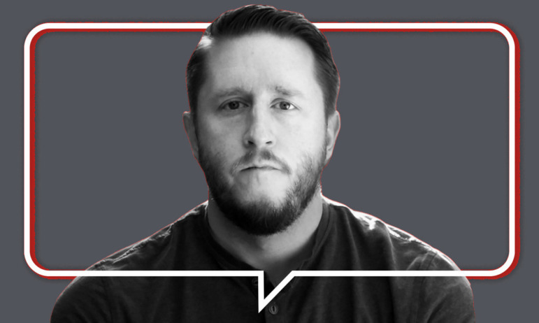 Student surveillance documentary "Sky High": Headshot serious-faced man in black and white with full beard and mustache in no-collar casual shirt on gray background