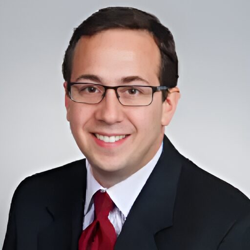 US Supreme Court religious charter school case:: Headshot man with short dark hair and glasses in black suit, white shirt & red tie.