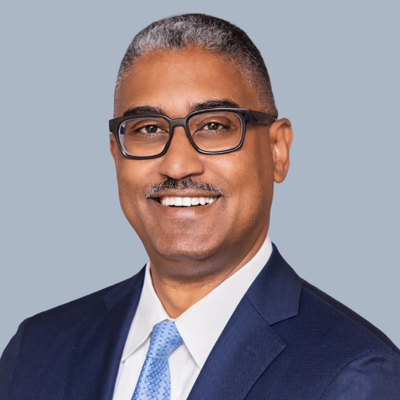 US Supreme Court religious charter school case:: Headshot Black man with short dark graying hair and glasses in navy suit, white shirt & light blue tie.