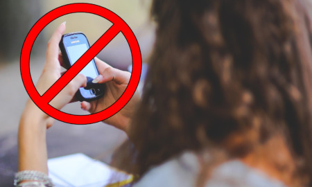 Cell phoe ban: Cell phone in hands of woman with red prohibited circle symbol over phone