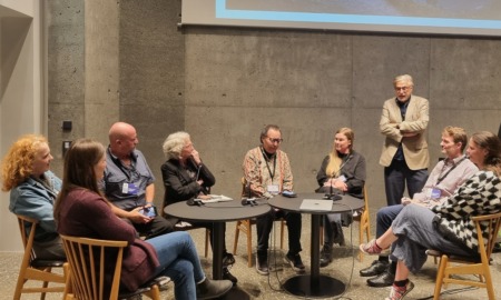 New opportunities to explore extended learning and youth development across the globe: group of professionals sit and discuss on stage in front of projector screen