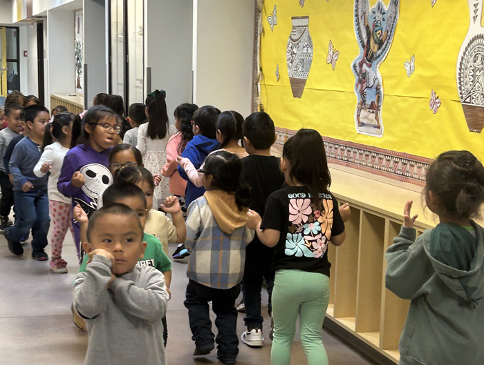 For some tribal communities, Head Start programs provide a cultural lifeline: children doing a traditional dance in school hallway