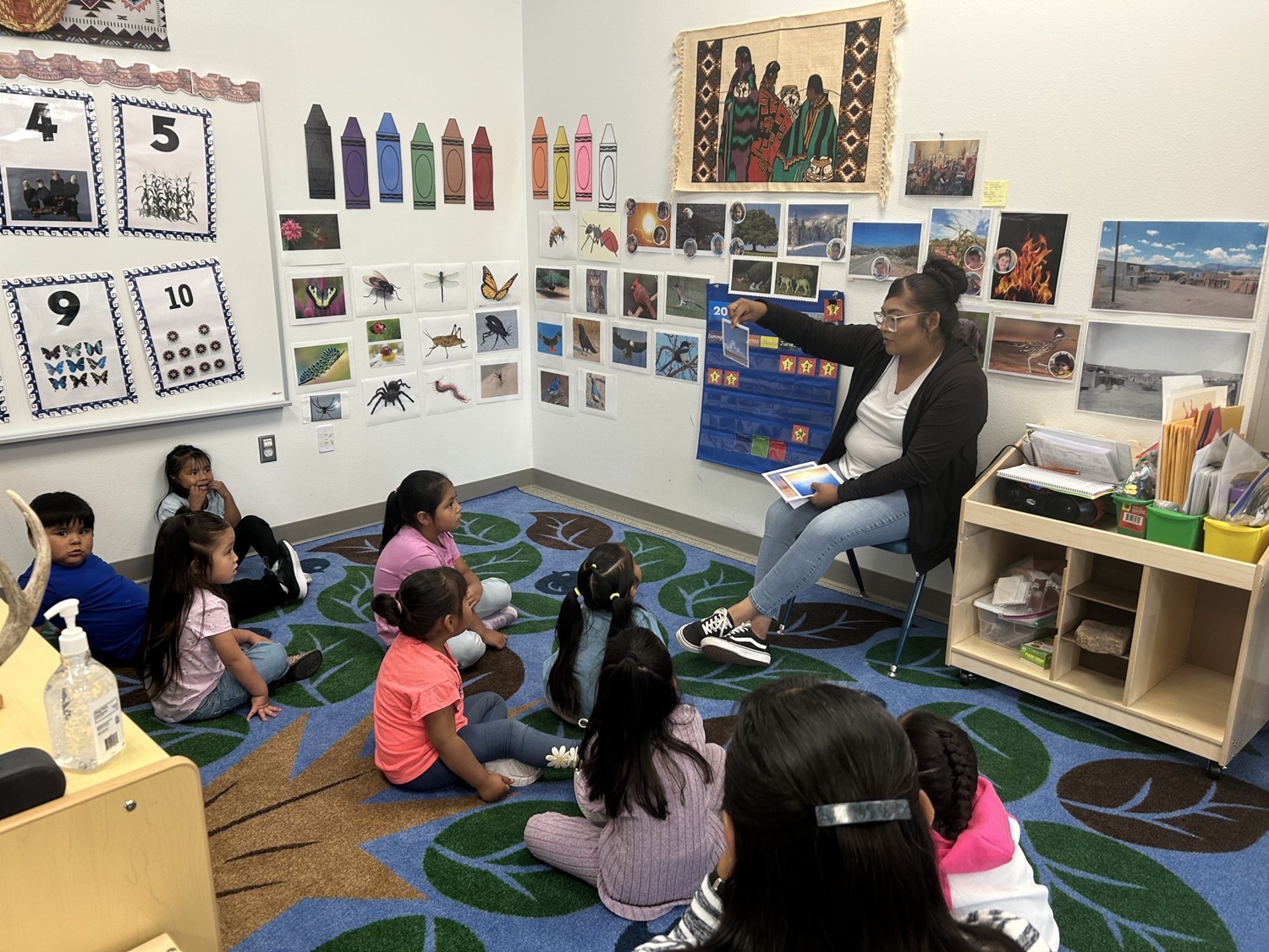 For some tribal communities, Head Start programs provide a cultural lifeline: children sitting on classroom floor while teacher holds up image