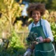 community food access: african american woman holding freshly picked kale from comnunal community garden posing for portrait