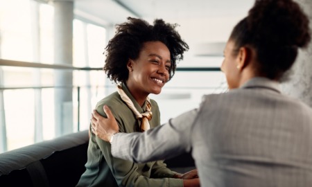 Reimagining the aging out mindset: young black woman smiling while being helped by mentor