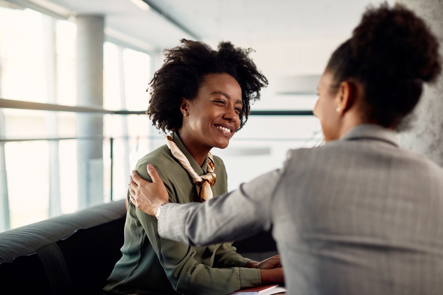 Reimagining the aging out mindset: young black woman smiling while being helped by mentor