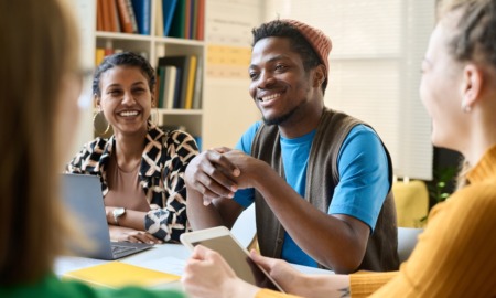 Foreign students education improvement grant: smiling diverse student working and talking at table