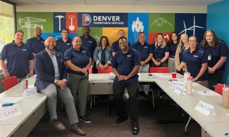 QA_Why the former CEO of AmeriCorps is excited about heading an organization he had never heard of_ opportunity youth _feature: group of people with matching dark blue shirts standing in room with "Denver Workforce Services" on wall