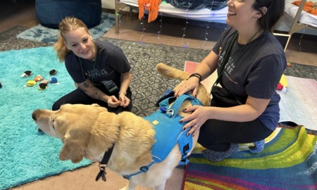The healing power of camp_Trauma-informed adventures for kids in foster care: two young female campers play with dog