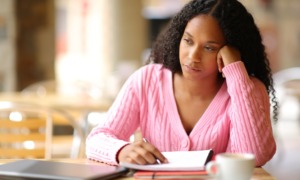 Grants to address dating/sexual violence and stalking on HBCU, HSI, and TCU campuses: worried or distracted black college student trying to work on classwork