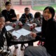 Expanding horizons, essential developmental relationships _evidence of afterschool impacts_feature: group of students and afterschool workers at a table outdoors doing work