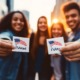 Crisis in GenZ political education_feature: group of youths holding "I voted" stickers outside